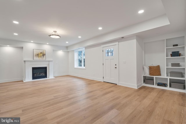 unfurnished living room with baseboards, recessed lighting, and light wood finished floors
