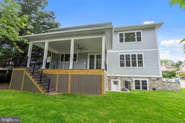 back of house with stairs, stone siding, a yard, and ceiling fan