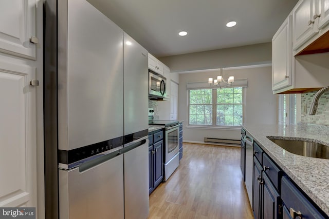 2 Rainflower Path Unit 102, Sparks Glencoe, MD 21152 - kitchen featuring appliances with stainless steel finishes, a sink, blue cabinetry, a baseboard heating unit, and light wood-style floors