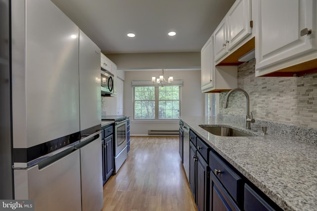 2 Rainflower Path Unit 102, Sparks Glencoe, MD 21152 - kitchen featuring appliances with stainless steel finishes, a sink, white cabinetry, backsplash, and a baseboard radiator