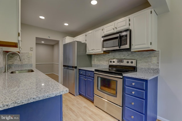 2 Rainflower Path Unit 102, Sparks Glencoe, MD 21152 - kitchen with appliances with stainless steel finishes, blue cabinets, a sink, light wood-style floors, and white cabinetry