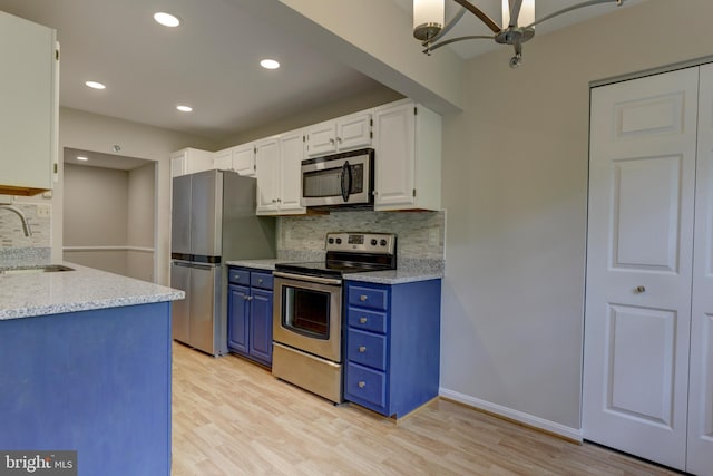 2 Rainflower Path Unit 102, Sparks Glencoe, MD 21152 - kitchen featuring appliances with stainless steel finishes, blue cabinetry, a sink, tasteful backsplash, and light wood-type flooring