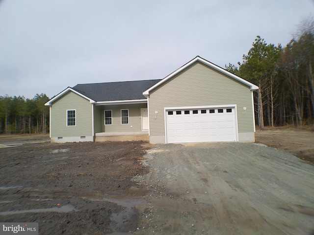 ranch-style house with a porch, dirt driveway, and a garage