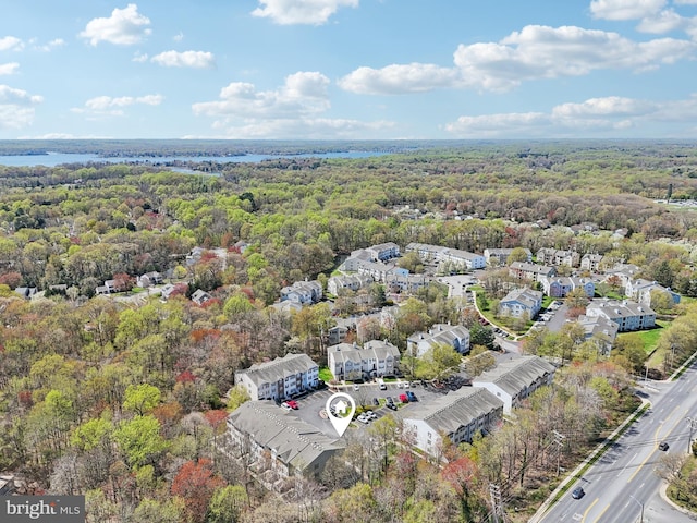 drone / aerial view featuring a wooded view and a water view
