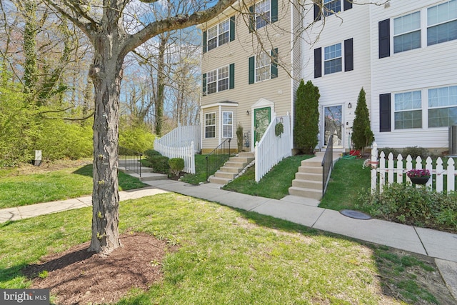 multi unit property with fence and a front lawn