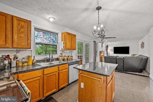 9525 Queens Guard Ct, Laurel, MD 20723 - kitchen featuring dishwasher, a sink, healthy amount of natural light, a kitchen island, and a textured ceiling
