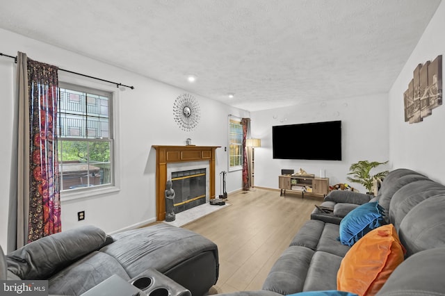 9525 Queens Guard Ct, Laurel, MD 20723 - living area with light wood-style flooring, a premium fireplace, a textured ceiling, baseboards, and recessed lighting