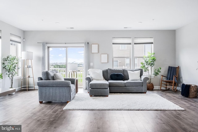 living area with a healthy amount of sunlight, baseboards, and wood finished floors