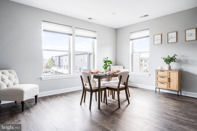 dining space featuring baseboards, dark wood finished floors, and visible vents