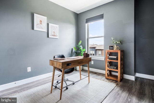 home office with baseboards and wood finished floors