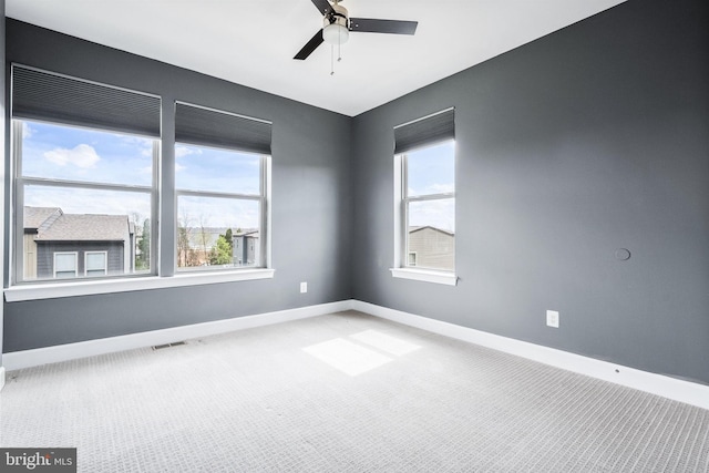 unfurnished room with ceiling fan, baseboards, carpet flooring, and a wealth of natural light