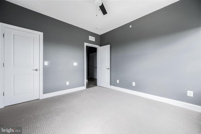 unfurnished bedroom featuring carpet, visible vents, baseboards, and ceiling fan