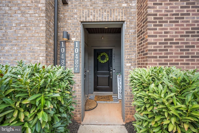 doorway to property featuring brick siding