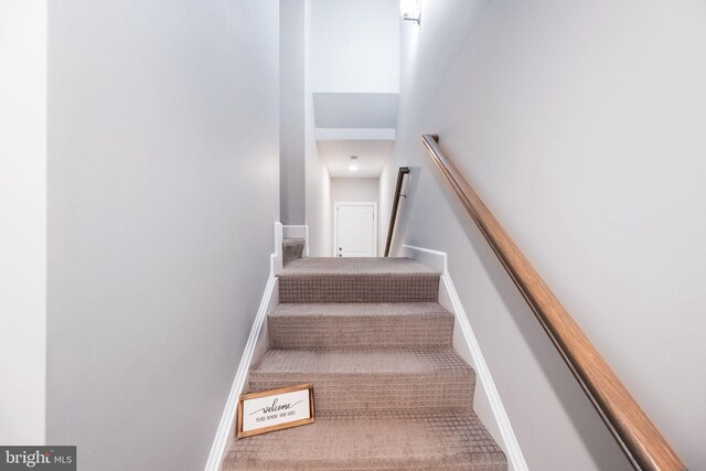 staircase featuring carpet flooring and baseboards