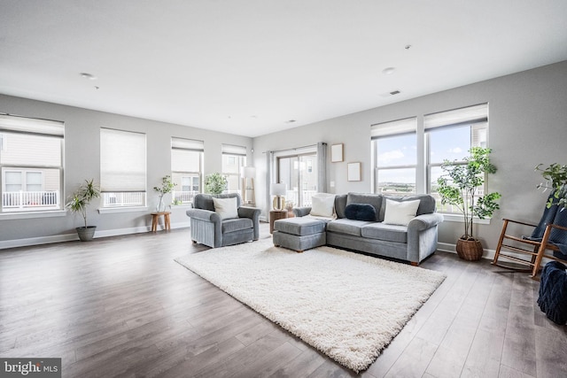 living room with wood finished floors, visible vents, and a wealth of natural light