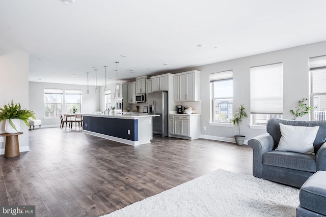 living area with dark wood-style flooring and baseboards