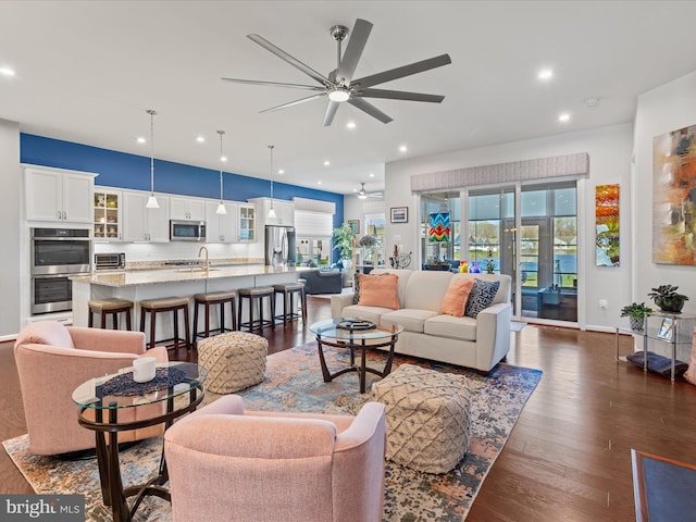 living area with baseboards, ceiling fan, recessed lighting, and dark wood-style flooring