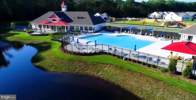 community pool featuring a patio, fence, and a lawn