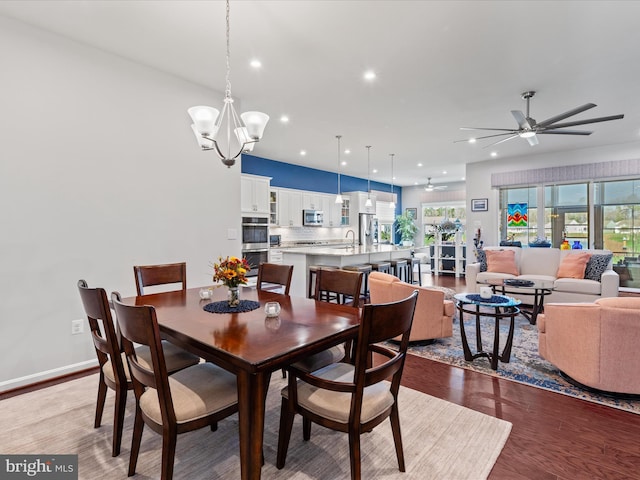 dining space with recessed lighting, ceiling fan with notable chandelier, baseboards, and wood finished floors