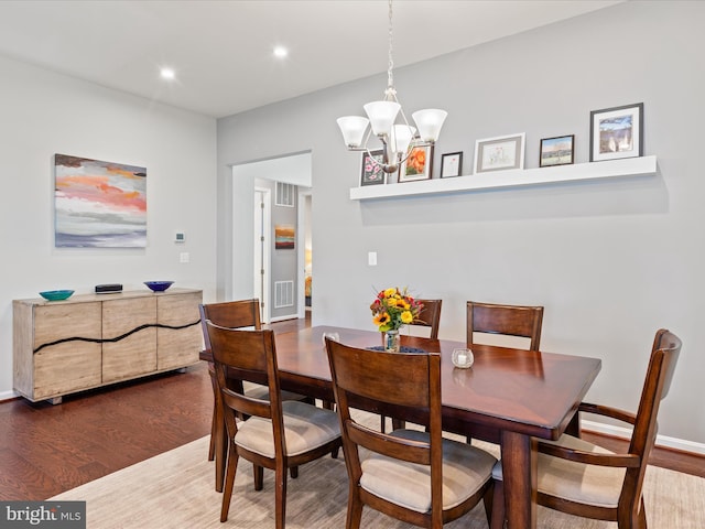 dining area with visible vents, baseboards, wood finished floors, recessed lighting, and a notable chandelier