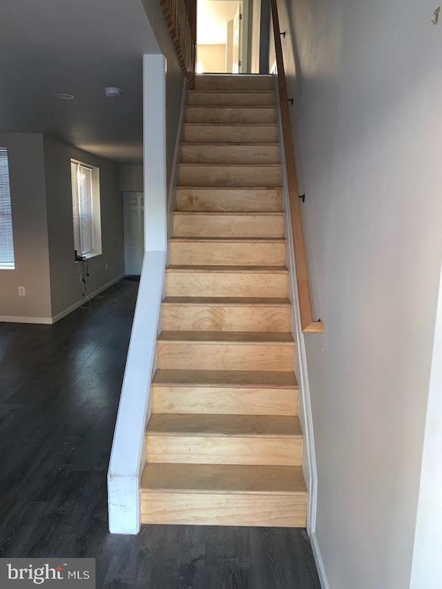 stairs featuring baseboards and wood finished floors