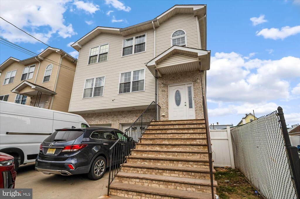 314 Goodwin St, Perth Amboy, NJ 08861 - multi unit property with fence, driveway, an attached garage, and brick siding