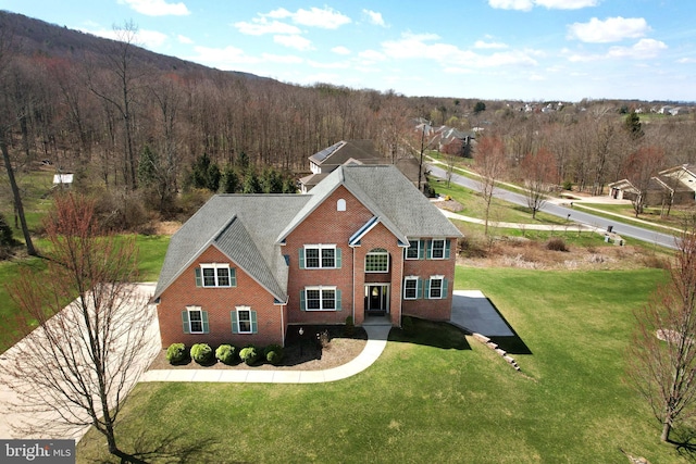 311 Treetops Dr, State College, PA 16801 - traditional-style home with brick siding, a front yard, and a forest view