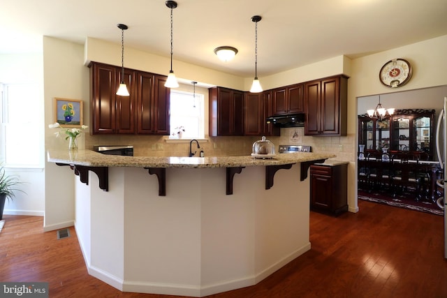 311 Treetops Dr, State College, PA 16801 - kitchen featuring visible vents, decorative backsplash, a kitchen breakfast bar, and under cabinet range hood