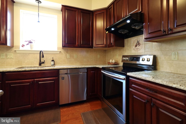 311 Treetops Dr, State College, PA 16801 - kitchen featuring under cabinet range hood, reddish brown cabinets, and appliances with stainless steel finishes