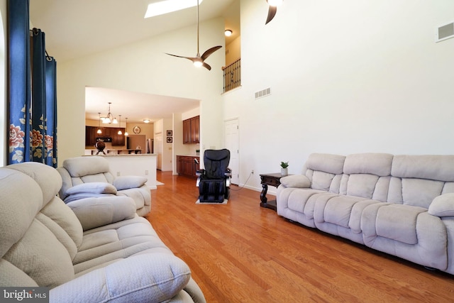 311 Treetops Dr, State College, PA 16801 - living area featuring light wood-type flooring, a towering ceiling, visible vents, a skylight, and a notable chandelier