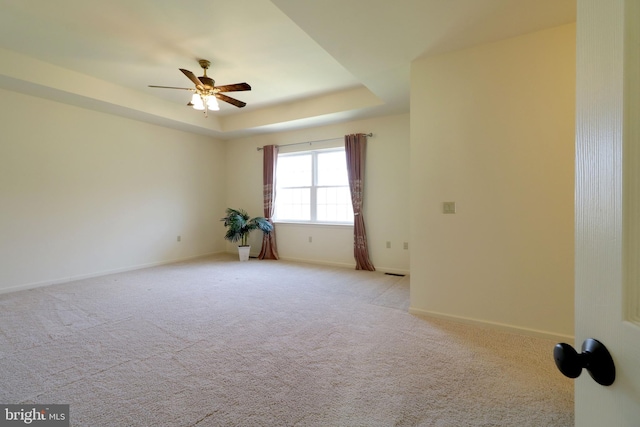 311 Treetops Dr, State College, PA 16801 - empty room featuring a tray ceiling, ceiling fan, baseboards, and light carpet