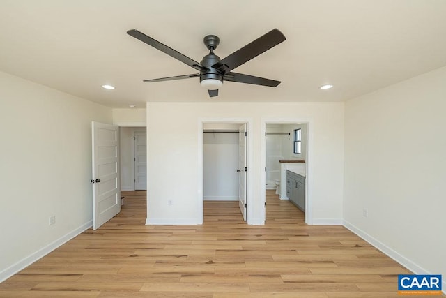 unfurnished bedroom with a spacious closet, baseboards, light wood-style floors, and recessed lighting