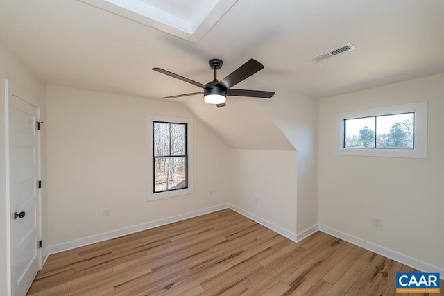 bonus room with light wood-style flooring, visible vents, baseboards, a ceiling fan, and lofted ceiling