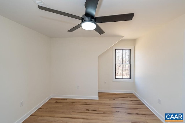 empty room with baseboards, ceiling fan, and light wood-style flooring