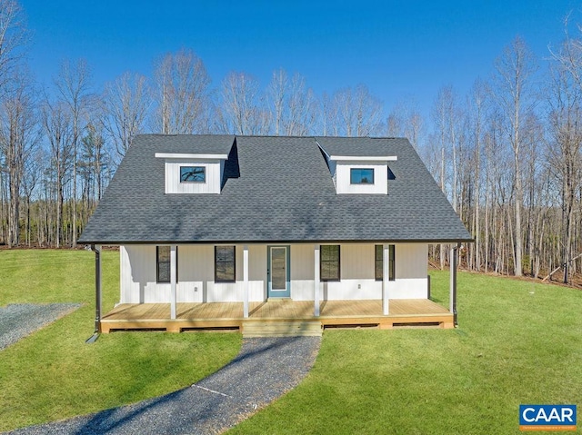 view of front of home featuring a shingled roof, a front yard, and covered porch
