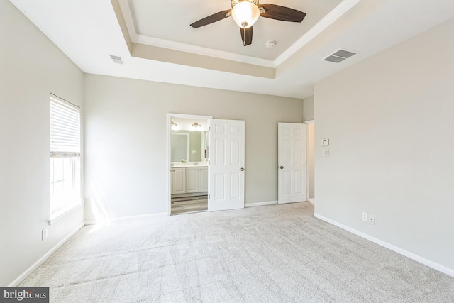 interior space with visible vents, a ceiling fan, a raised ceiling, and light carpet