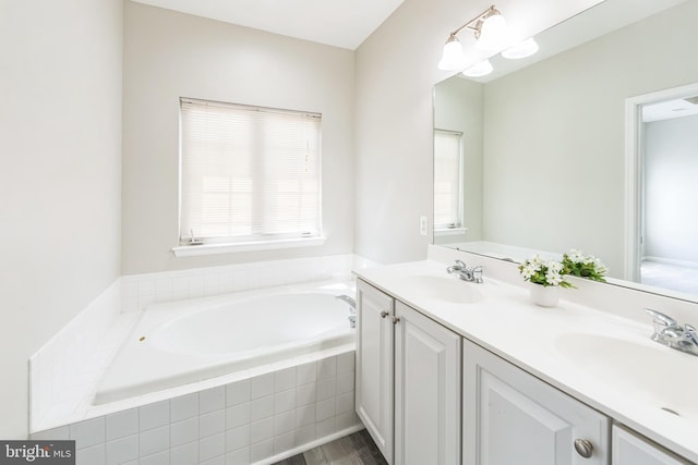 full bath with a sink, double vanity, and a bath