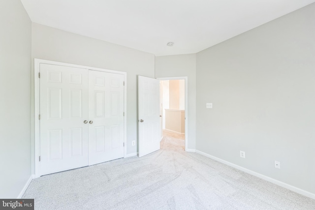 unfurnished bedroom with a closet, carpet, and baseboards