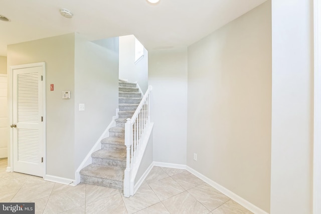 staircase with tile patterned floors and baseboards