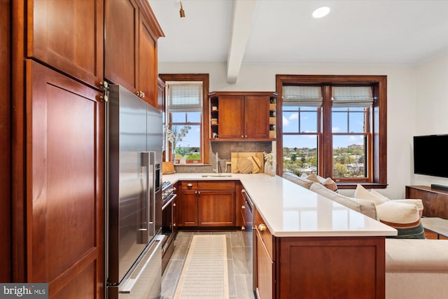 2853 Ontario Rd NW Unit 609, Washington, DC 20009 - kitchen featuring appliances with stainless steel finishes, a peninsula, open floor plan, light countertops, and tasteful backsplash