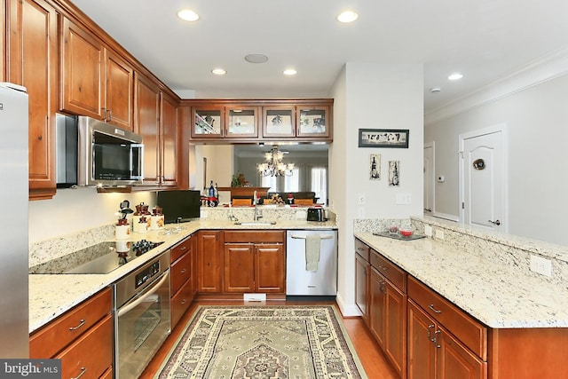 kitchen with glass insert cabinets, an inviting chandelier, a sink, appliances with stainless steel finishes, and a peninsula