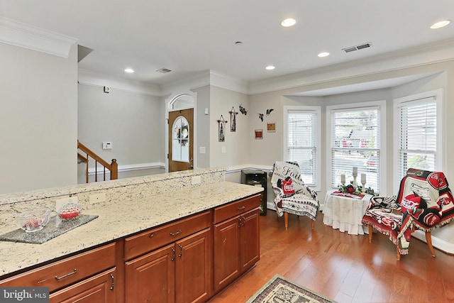 kitchen featuring light wood-style floors, ornamental molding, light stone countertops, and recessed lighting