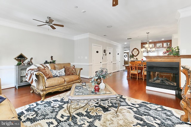 living area featuring ceiling fan with notable chandelier, wood finished floors, and ornamental molding