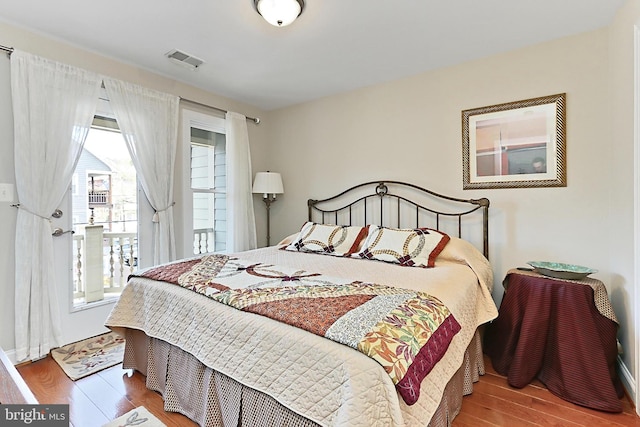 bedroom featuring wood finished floors and visible vents