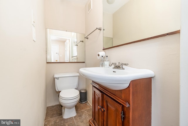 bathroom featuring visible vents, toilet, and vanity