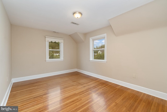 bonus room featuring baseboards, visible vents, a healthy amount of sunlight, and light wood-style floors