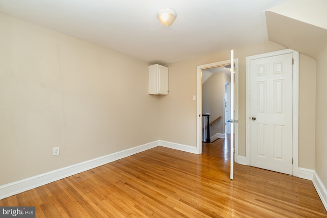 unfurnished room featuring baseboards and light wood-style floors