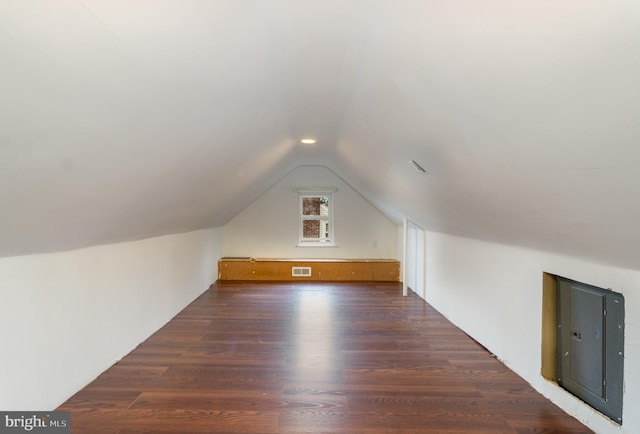 bonus room with lofted ceiling, visible vents, wood finished floors, and electric panel