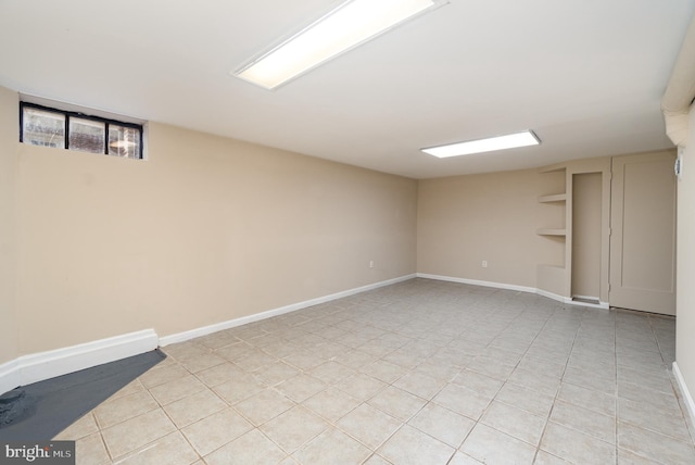 below grade area with light tile patterned floors and baseboards