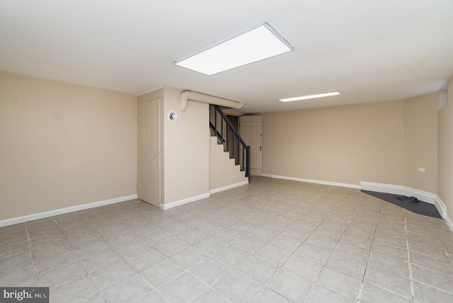 finished basement featuring baseboards and stairway